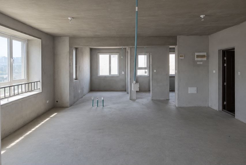 The space before the work: bare concrete walls and floor